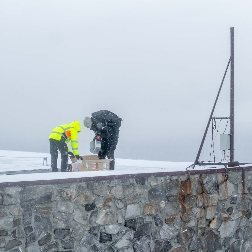 To teknikere monterer Panomax 360° kamera i snøvær på Nordkapp.